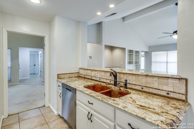 kitchen with light stone countertops, stainless steel dishwasher, light carpet, sink, and white cabinetry