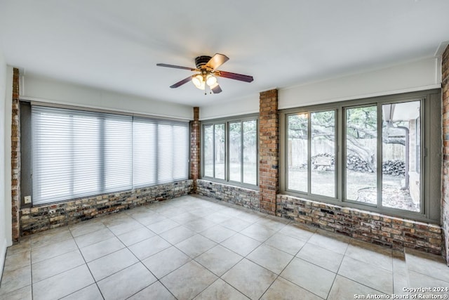 unfurnished sunroom with ceiling fan