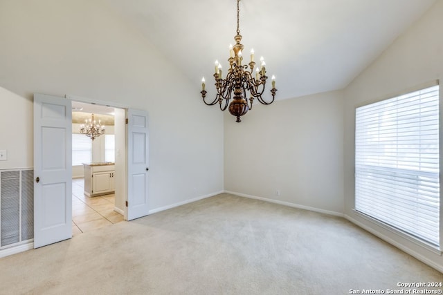 empty room with light carpet, high vaulted ceiling, and an inviting chandelier