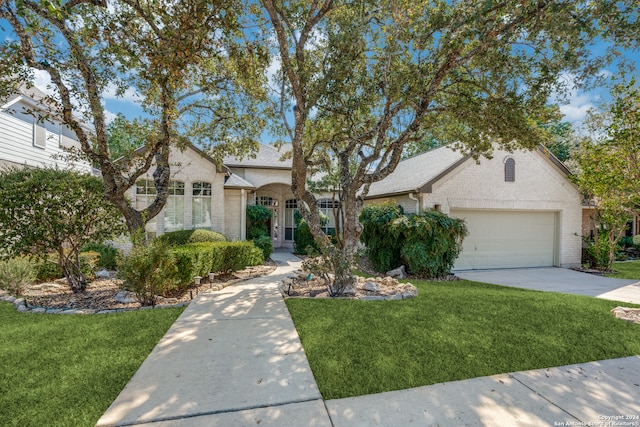 single story home featuring a front lawn and a garage