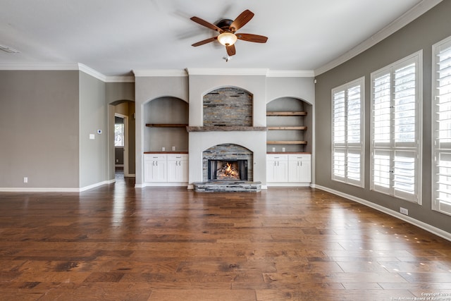 unfurnished living room with ornamental molding, ceiling fan, dark hardwood / wood-style floors, and built in shelves