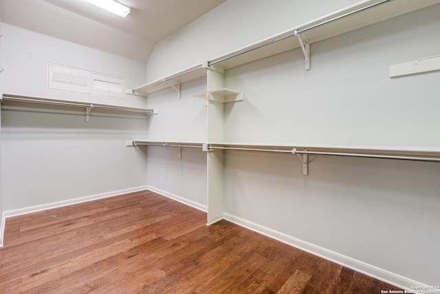 walk in closet with hardwood / wood-style floors and lofted ceiling