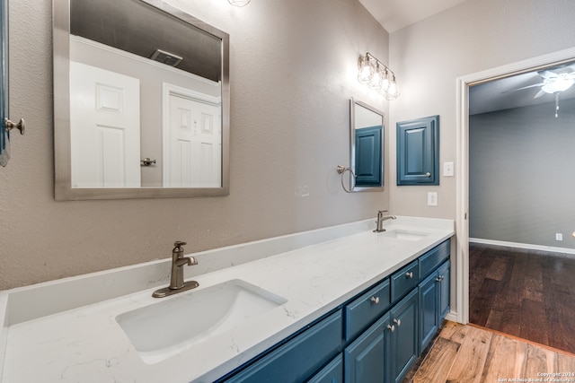 bathroom with wood-type flooring, vanity, and ceiling fan