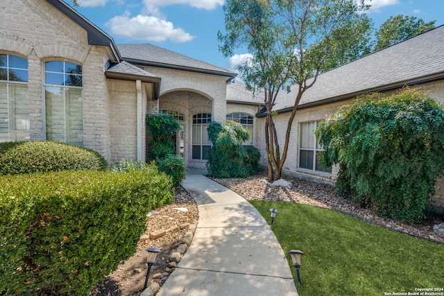 entrance to property featuring a lawn