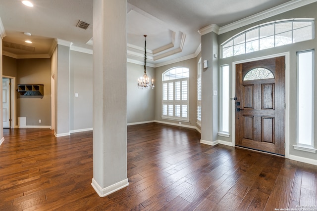 entrance foyer with a notable chandelier, crown molding, and dark hardwood / wood-style floors