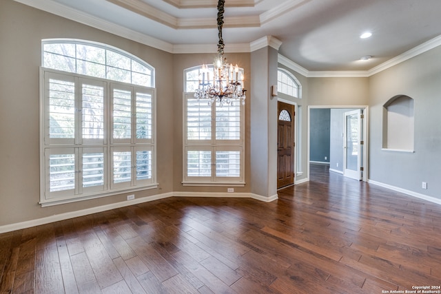 unfurnished dining area featuring a healthy amount of sunlight, crown molding, and a chandelier