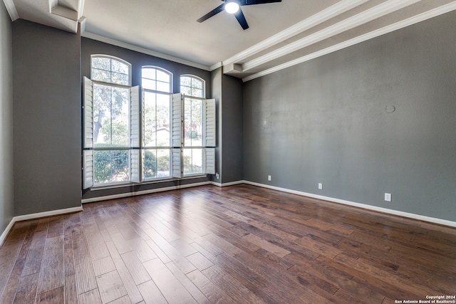 empty room featuring ceiling fan, crown molding, and dark wood-type flooring