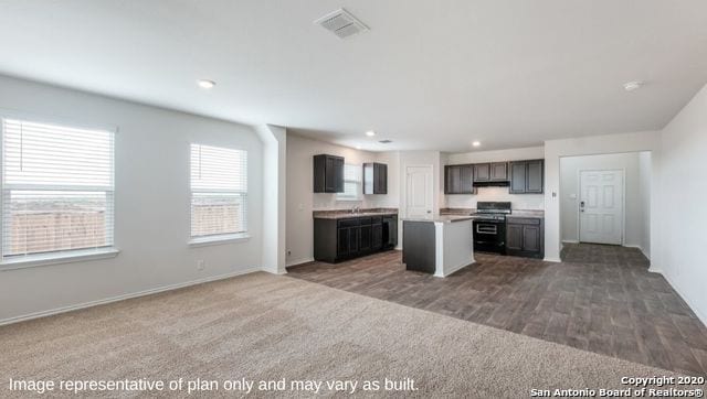 kitchen featuring carpet flooring, black range oven, and a kitchen island