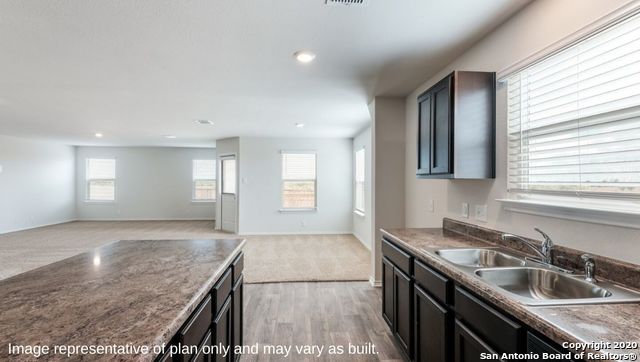 kitchen with dark brown cabinets, sink, and light hardwood / wood-style floors