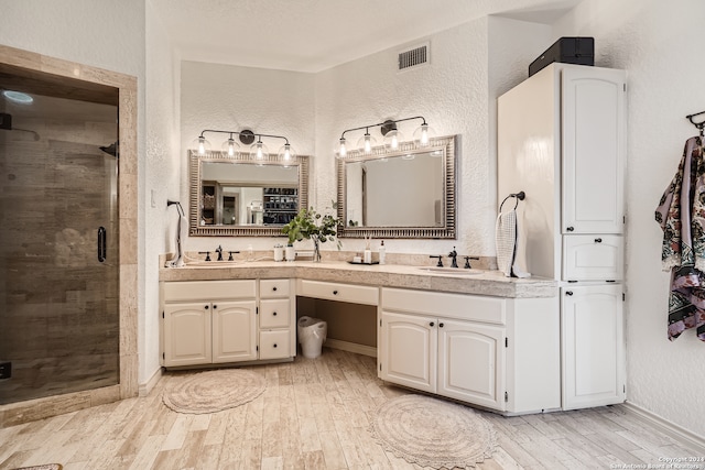 bathroom featuring vanity, wood-type flooring, and an enclosed shower