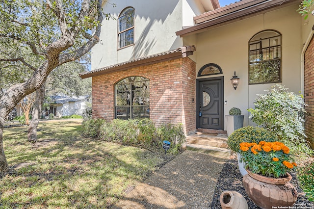 view of exterior entry featuring a yard