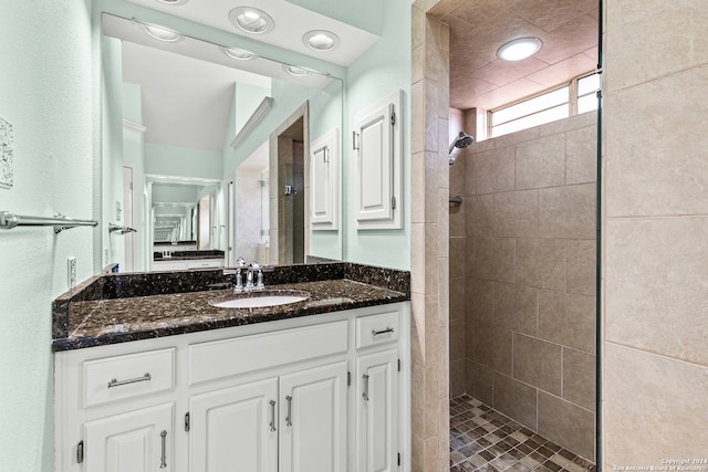 bathroom featuring a tile shower and vanity