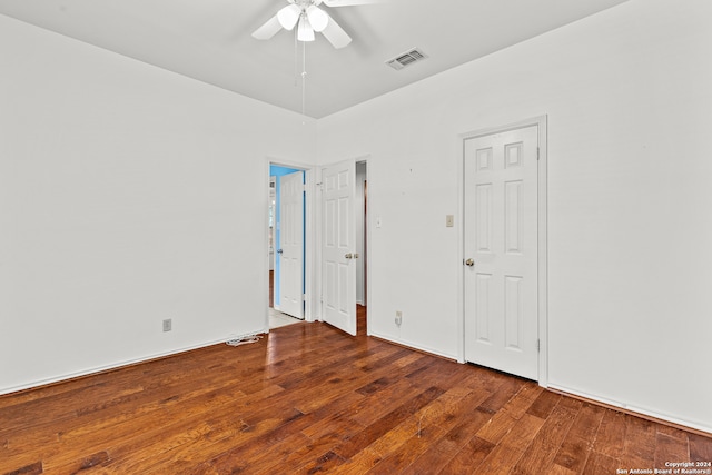 empty room featuring ceiling fan and dark hardwood / wood-style flooring