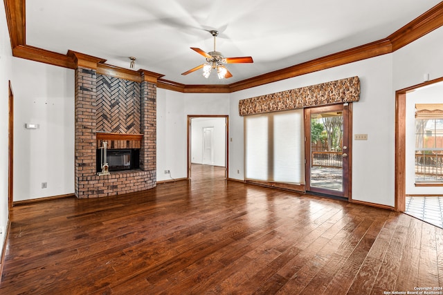 unfurnished living room with plenty of natural light, ornamental molding, dark hardwood / wood-style floors, and a brick fireplace