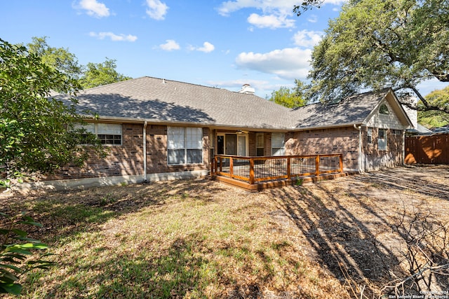 rear view of property featuring a deck and a yard