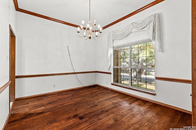 spare room with an inviting chandelier, hardwood / wood-style floors, and ornamental molding