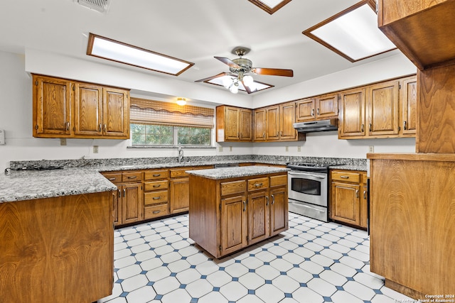 kitchen with ceiling fan, sink, a center island, and stainless steel electric range