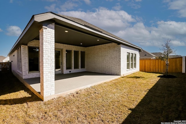 rear view of property featuring a patio area and a lawn