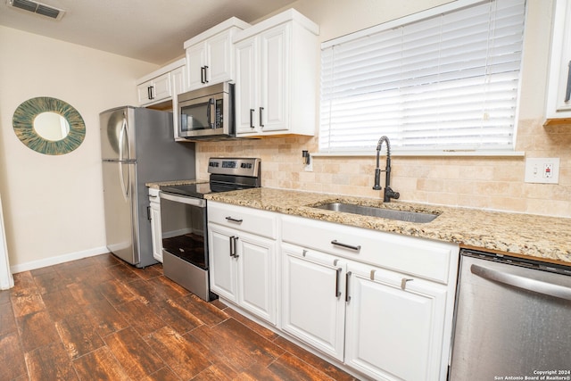 kitchen with sink, tasteful backsplash, dark wood-type flooring, white cabinetry, and stainless steel appliances