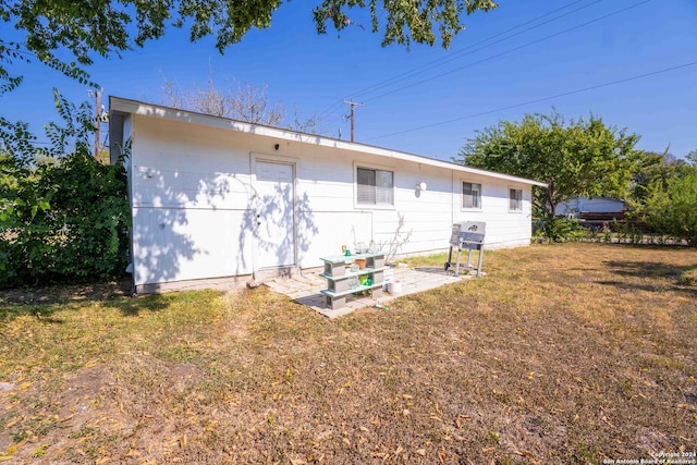 rear view of house featuring a patio and a yard