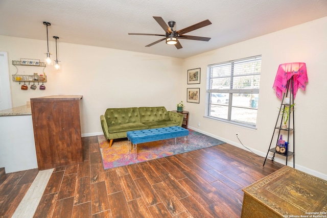 sitting room with ceiling fan, dark hardwood / wood-style floors, and a textured ceiling