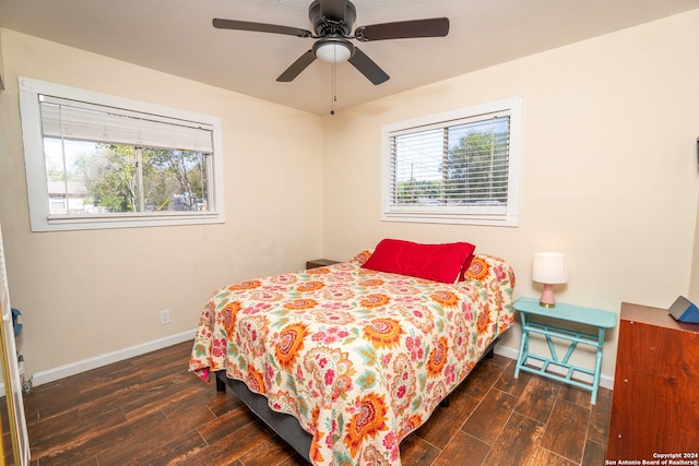 bedroom featuring dark hardwood / wood-style flooring, multiple windows, and ceiling fan