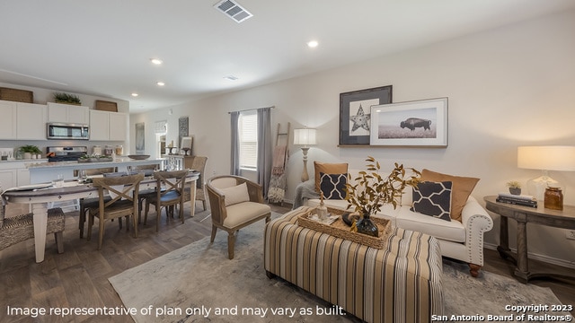 living area featuring visible vents, recessed lighting, and wood finished floors