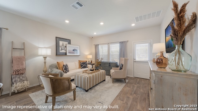 living room with visible vents, recessed lighting, and wood finished floors