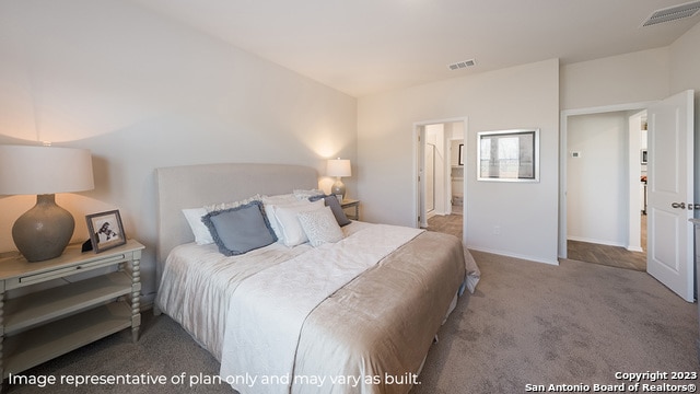 carpeted bedroom featuring visible vents