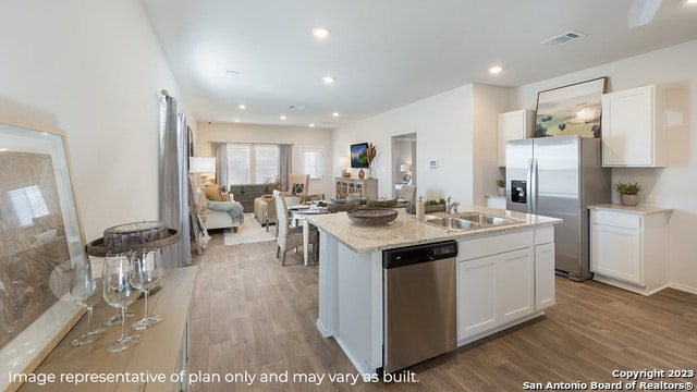 kitchen featuring appliances with stainless steel finishes, a sink, visible vents, and light wood-type flooring