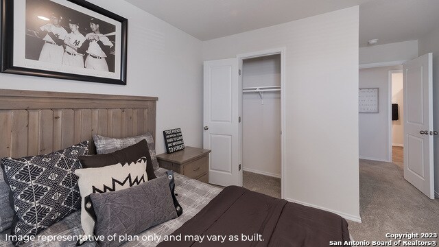 carpeted bedroom featuring a closet and baseboards