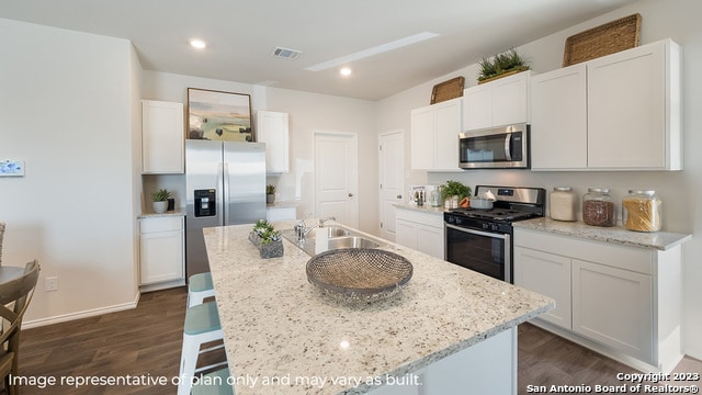 kitchen with a sink, white cabinets, dark wood-style floors, and stainless steel appliances