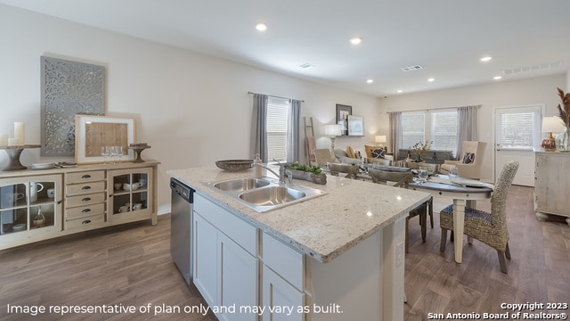 kitchen with wood finished floors, a sink, dishwasher, and open floor plan
