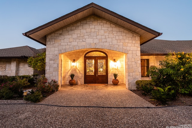 exterior entry at dusk featuring french doors