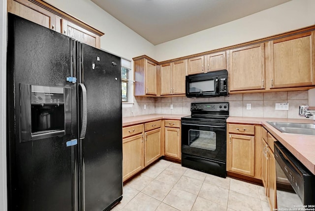 kitchen featuring light tile patterned floors, sink, tasteful backsplash, black appliances, and light brown cabinetry