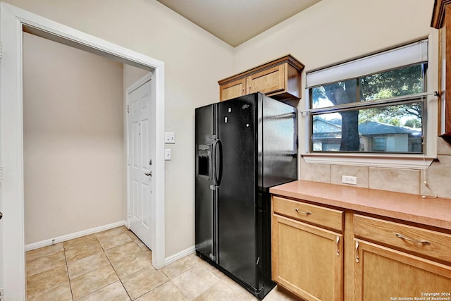 kitchen with light tile patterned flooring and black refrigerator with ice dispenser