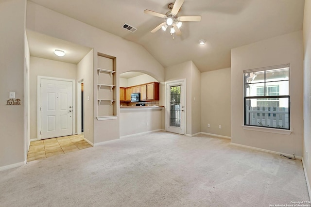 unfurnished living room featuring lofted ceiling, ceiling fan, and light carpet