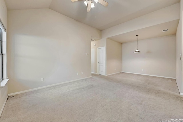 empty room featuring light carpet, vaulted ceiling, and ceiling fan