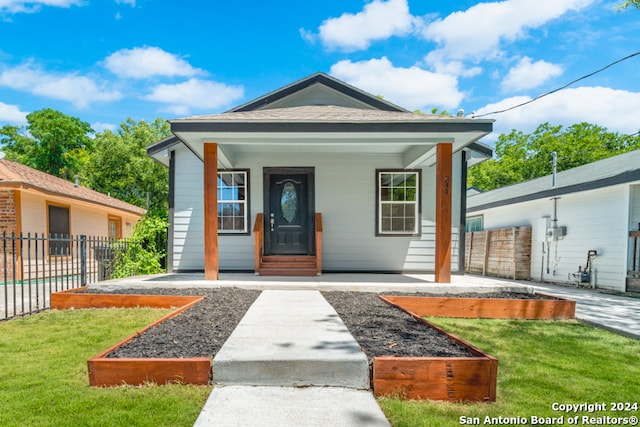 bungalow-style house with a porch and a front lawn