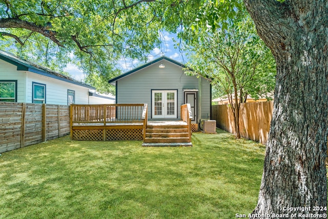 rear view of house with french doors, a deck, a yard, and central AC