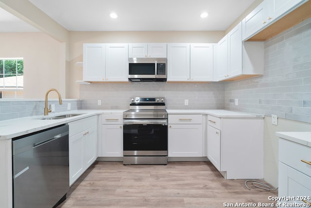 kitchen featuring appliances with stainless steel finishes, white cabinetry, and sink