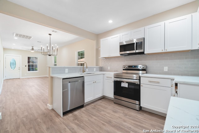 kitchen featuring sink, appliances with stainless steel finishes, light hardwood / wood-style flooring, and white cabinetry