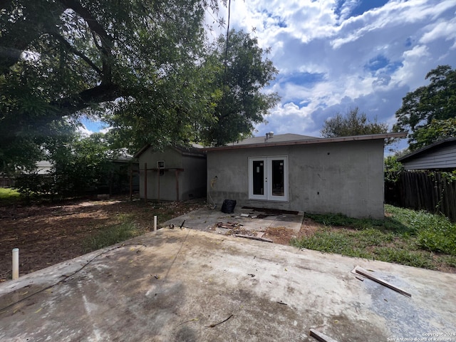 rear view of house featuring french doors, a patio, and a shed