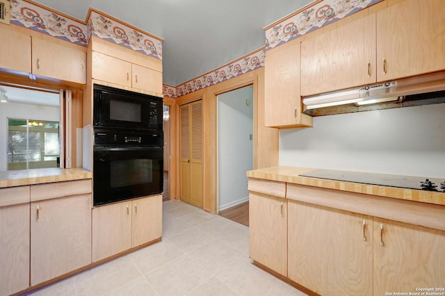 kitchen featuring light tile patterned floors, black appliances, and light brown cabinets