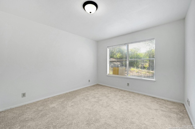 unfurnished room featuring light carpet