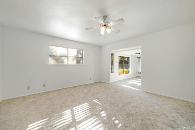 carpeted spare room with ceiling fan and a healthy amount of sunlight