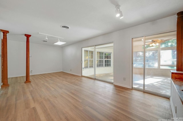 unfurnished room with ceiling fan, light wood-type flooring, ornate columns, and rail lighting