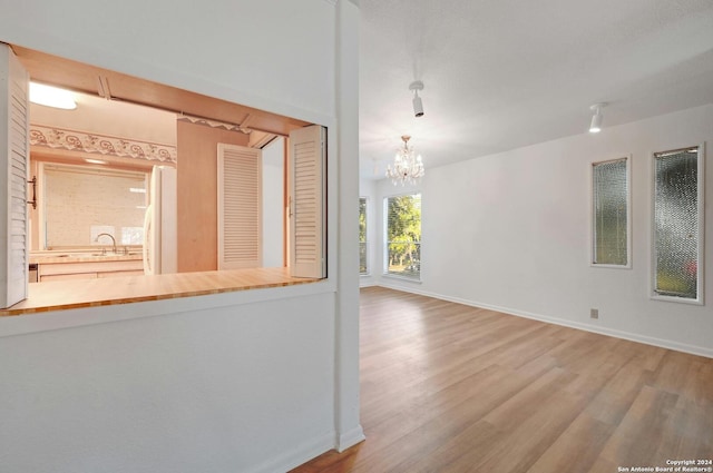 unfurnished room with a chandelier, hardwood / wood-style flooring, and sink