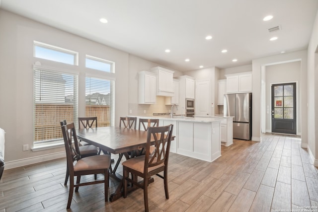 dining room with light hardwood / wood-style flooring and sink