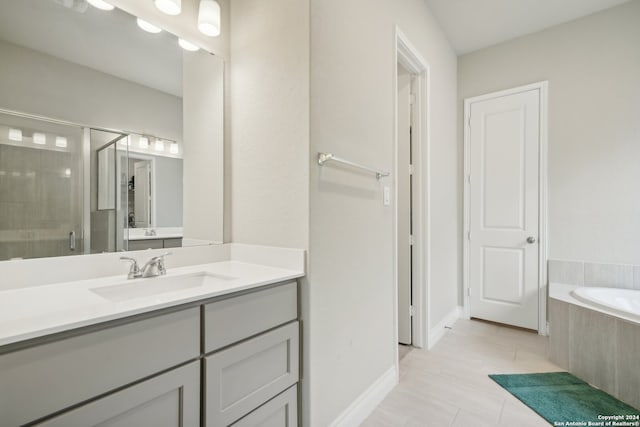 bathroom with tile patterned flooring, vanity, and independent shower and bath